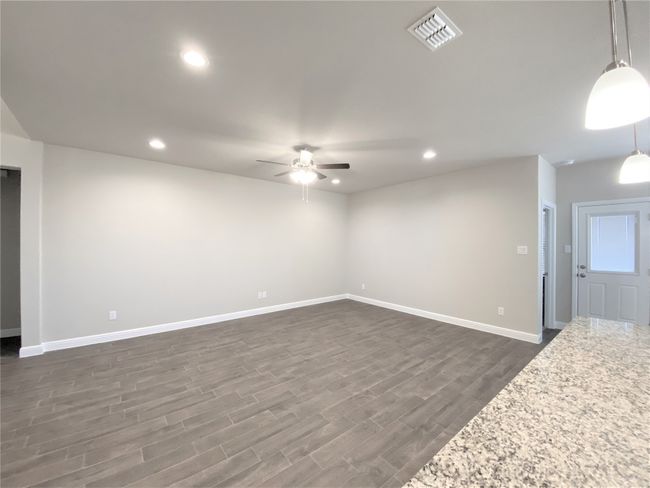 Unfurnished living room with ceiling fan, dark wood-style floors, and recessed lighting | Image 4
