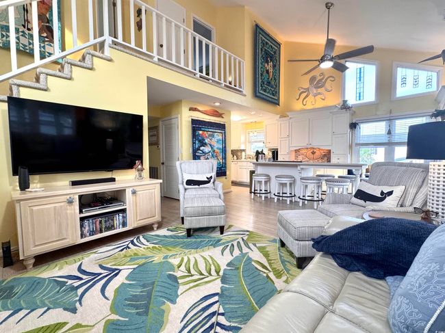 Living area featuring ceiling fan, a high ceiling, and light wood-style flooring | Image 20