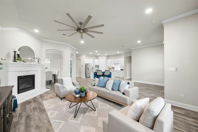 The expansive open-concept living room is bathed in natural light, creating a warm and inviting atmosphere. | Image 9