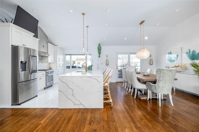 Kitchen with plenty of natural light, a sink, wall chimney exhaust hood, and appliances with stainless steel finishes | Image 6