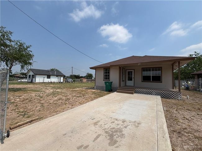 Bungalow-style home featuring fence, stucco siding, and covered porch | Image 9