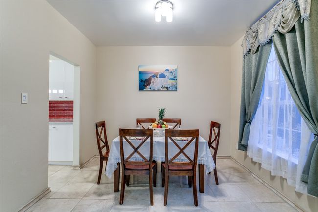 Dining space featuring light tile patterned flooring and baseboards | Image 6