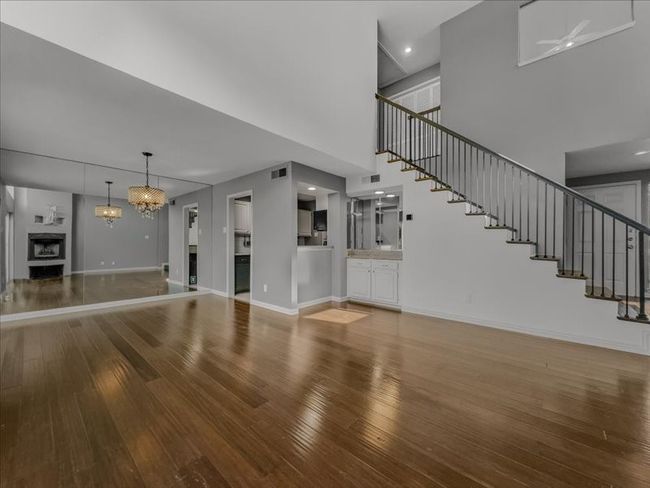 Living room with a high ceiling, hardwood / wood-style floors, and a chandelier | Image 7