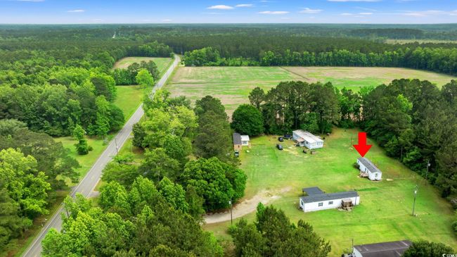 Aerial view of sparsely populated area with a heavily wooded area | Image 37