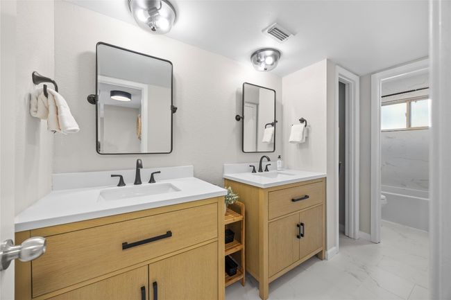 Updated in April 2025 the primary bathroom has two beautiful vanities and a linen closet | Image 17