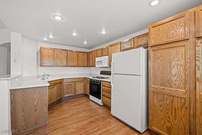 The gourmet kitchen features plenty of countertop space, a breakfast bar, and a charming nook—perfect for casual dining or morning coffee. The generously sized living room flows seamlessly to a private balcony, creating the ideal setting for relaxation and indoor-outdoor enjoyment. | Image 17