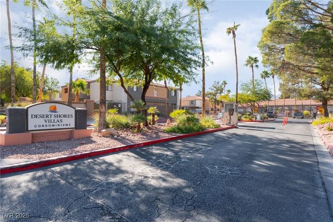 View of asphalt street featuring a residential view, a gated entry, and curbs | Image 37