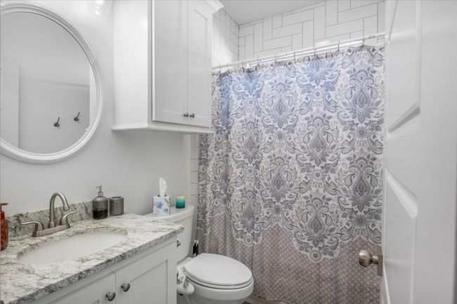Full bath featuring toilet, a shower with curtain, and vanity | Image 25