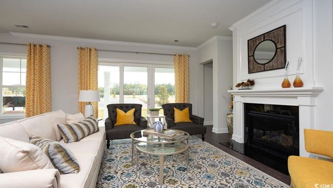 Living area featuring crown molding, plenty of natural light, wood finished floors, and visible vents | Image 13