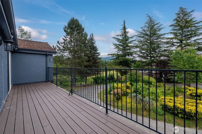 Upstairs, two bedrooms share access to a generous sun balcony overlooking English gardens and the foothills beyond. | Image 23
