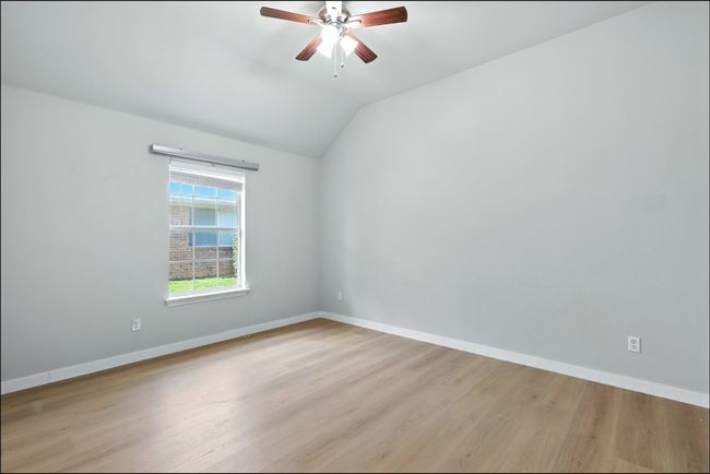 Unfurnished room with ceiling fan, lofted ceiling, and light wood-type flooring | Image 9