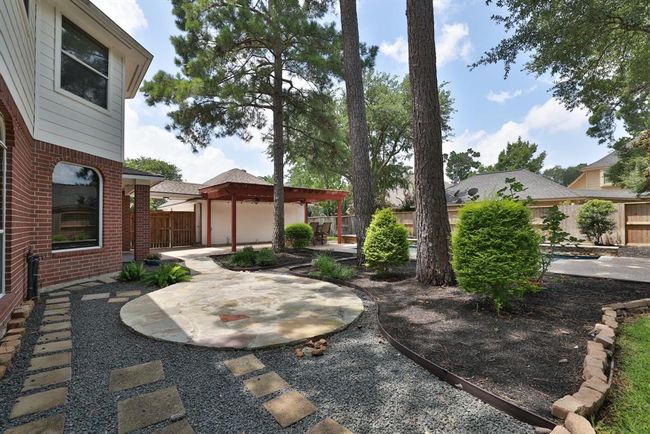 Eating area or fire pit area and stone walkway to pool equipment | Image 40