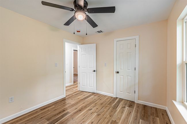 Unfurnished bedroom featuring ceiling fan, baseboards, visible vents, and light wood-type flooring | Image 20