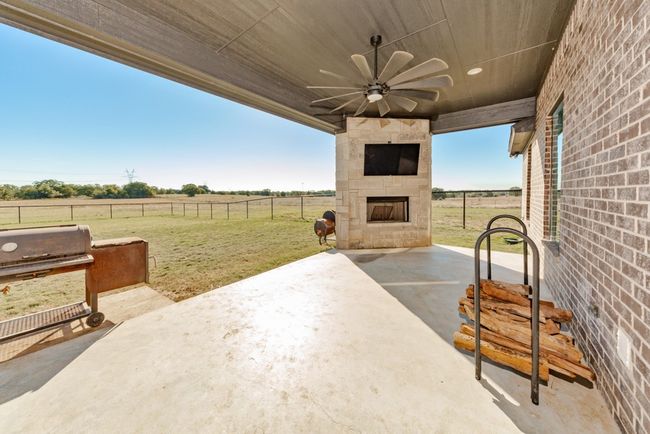 View of patio / terrace featuring a ceiling fan, fence, grilling area, and a fireplace | Image 38