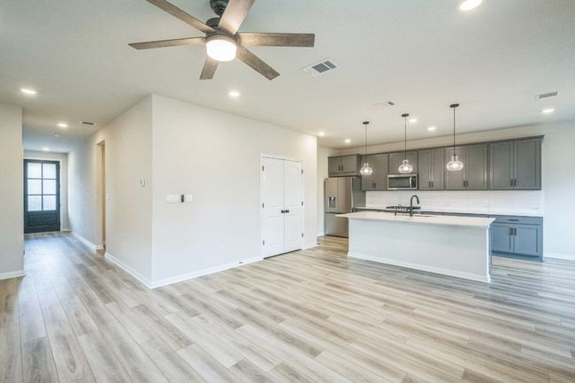 Kitchen featuring appliances with stainless steel finishes, recessed lighting, light countertops, light wood-style floors, and a sink | Image 6