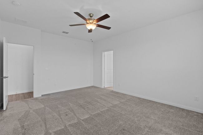 Empty room with carpet, ceiling fan, and a smoke detector | Image 20