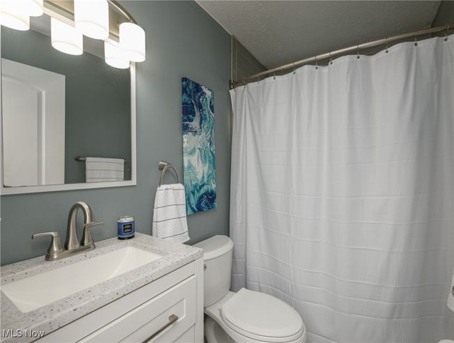 Bathroom featuring vanity and curtained shower | Image 14