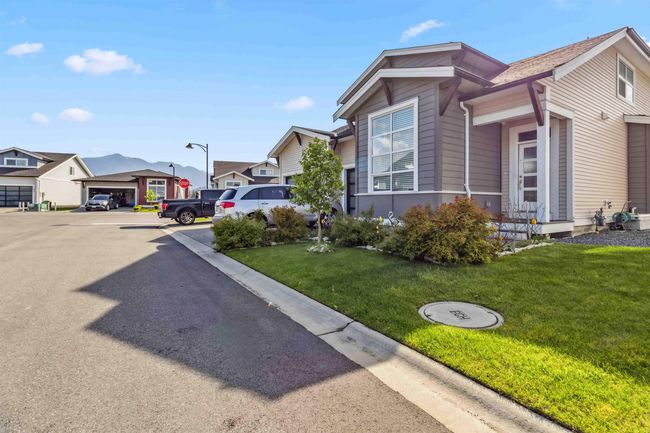 View of side of property featuring uncovered parking, a residential view, and a yard | Image 5