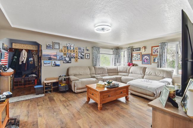 Living area with a textured ceiling and wood finished floors | Image 5