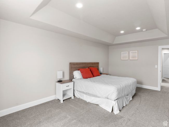 Bedroom featuring recessed lighting, light carpet, a raised ceiling, and baseboards | Image 11