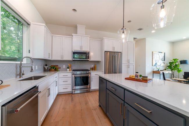 Kitchen with stainless steel appliances, white cabinets, decorative backsplash, and recessed lighting | Image 10