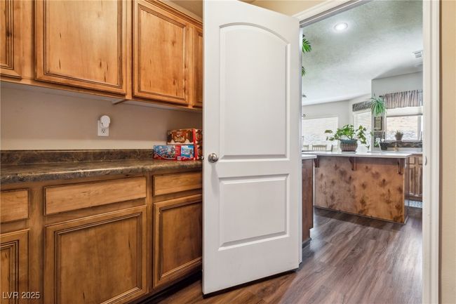 Kitchen with dark wood-style floors, brown cabinets, dark countertops, and recessed lighting | Image 21