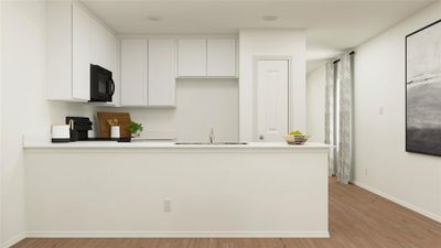 Kitchen with white cabinets, sink, kitchen peninsula, black appliances, and light wood-type flooring | Image 3