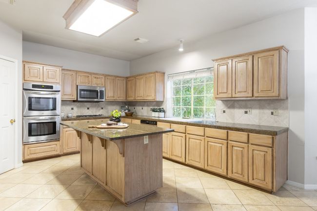 Large kitchen space with newer stainless appliances and a great view of the private back yard. | Image 11