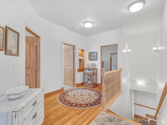 Corridor featuring baseboards, an upstairs landing, and light wood finished floors | Image 23