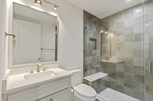 2nd bedroom en-suite with quartz counter tops and tile surround shower | Image 17