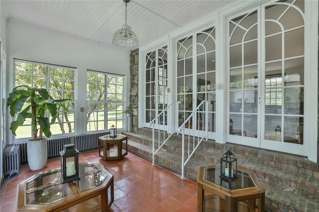 Veranda / solarium featuring a wealth of natural light, french doors to access the living room and adjoins the screen porch | Image 13