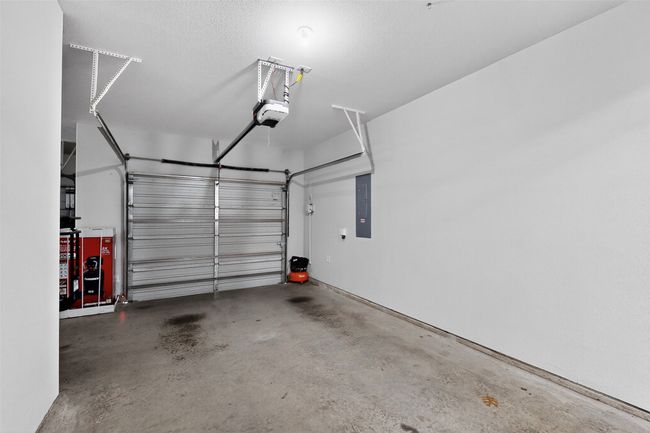 3rd car garage featuring electric panel and a garage door opener | Image 39
