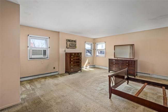 Bedroom featuring cooling unit, baseboard heating, a wall mounted AC, and carpet floors | Image 15