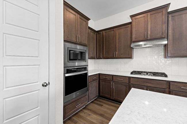 Kitchen with appliances with stainless steel finishes, range hood, and light countertops | Image 17