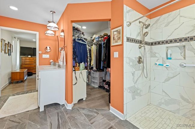 Bathroom with a spacious closet and large walk/roll in shower with seat. | Image 21