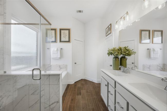 The spa-like primary bath features dual vanities, modern fixtures, and a beautifully designed shower, creating a calm, polished space where your morning routine feels indulgent. | Image 19