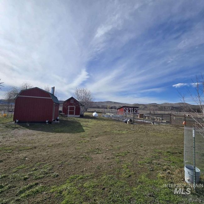 View of yard featuring a barn, an outbuilding, and a mountain view | Image 25