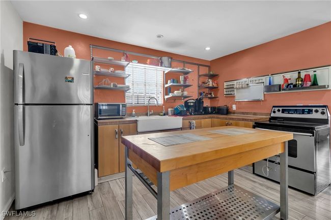 Kitchen featuring open shelves, stainless steel appliances, a sink | Image 19
