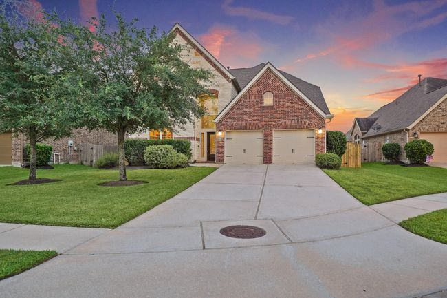 This inviting home features a charming brick exterior with a three-car garage. The well-maintained front yard has lush greenery and a tree, while the driveway offers ample parking space. Great curb appeal. | Image 38