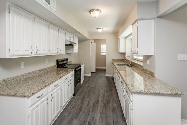 Empty room with a ceiling fan, carpet floors, ornamental molding, and a chandelier | Image 7
