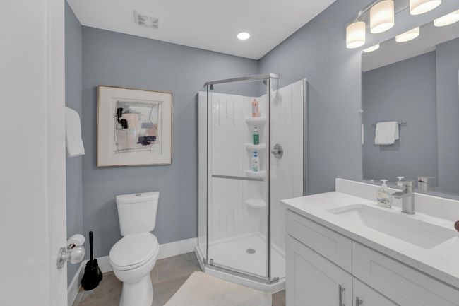 Bathroom with visible vents, a shower stall, toilet, tile patterned floors, and vanity | Image 19