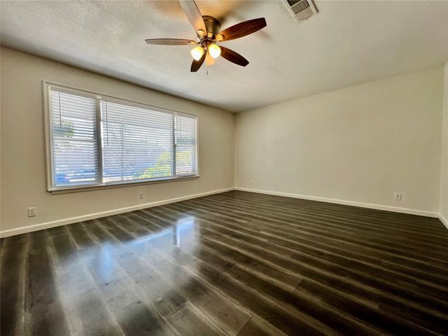 Unfurnished room with dark wood finished floors, a ceiling fan, and baseboards | Image 11