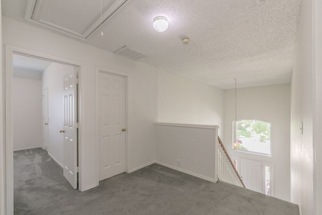 Unfurnished room featuring a textured ceiling, carpet, visible vents, and baseboards | Image 26