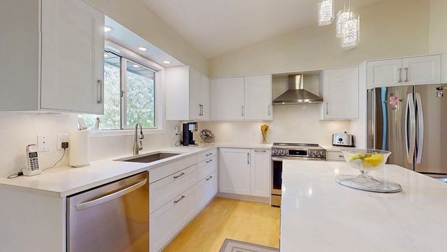 Kitchen featuring island, lofted ceiling, and light countertops | Image 5
