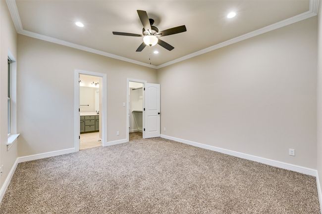 Bedroom featuring light/fan, carpet, a spacious closet, baseboards, recessed lighting, and crown molding | Image 10