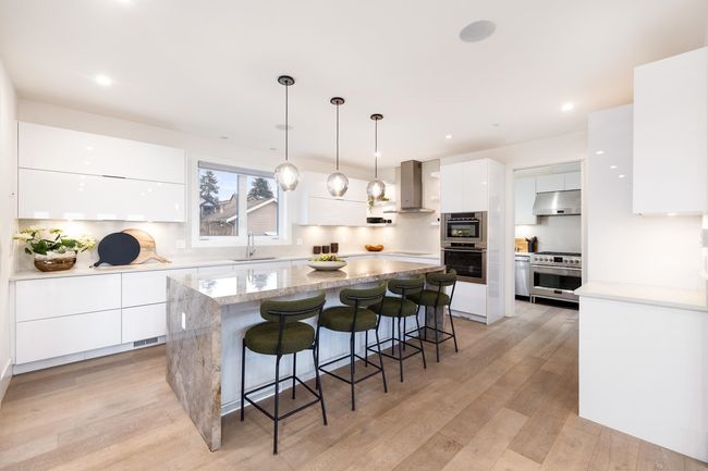 Kitchen with modern cabinets, a sink, white cabinetry, exhaust hood, and light wood finished floors | Image 7
