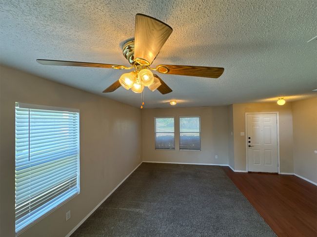 Unfurnished room featuring a textured ceiling, ceiling fan, and hardwood / wood-style flooring | Image 4