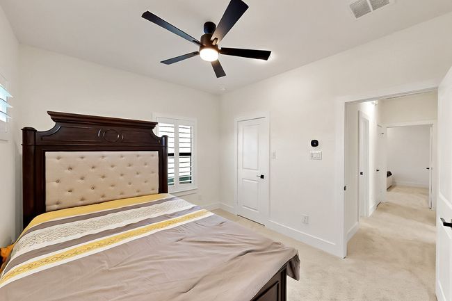 Bedroom with light colored carpet, baseboards, and ceiling fan | Image 35