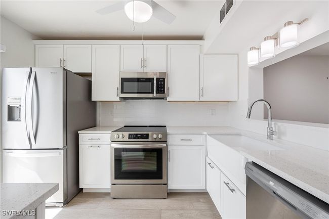 Renovated Kitchen with white cabinets, stainless steel appliances and sleek white tile backsplash | Image 6