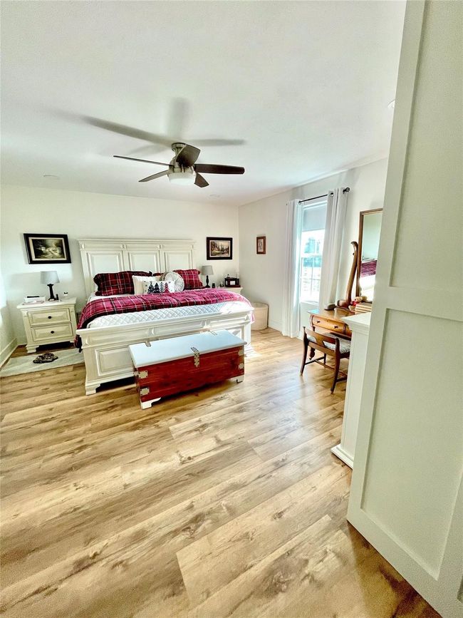 Bedroom featuring light wood-type flooring and a ceiling fan | Image 10